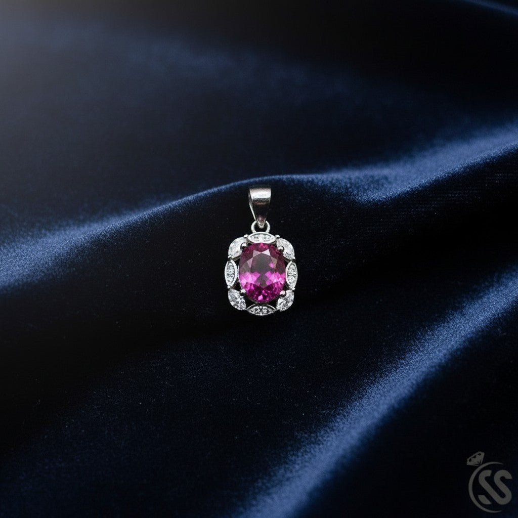 SilverStones.Pk oval ruby pendant surrounded by small clear stones, crafted in rhodium-plated sterling silver.