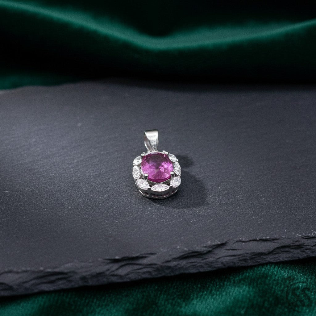 SilverStones.Pk oval real ruby pendant surrounded by small clear stones, crafted in rhodium-plated sterling silver.