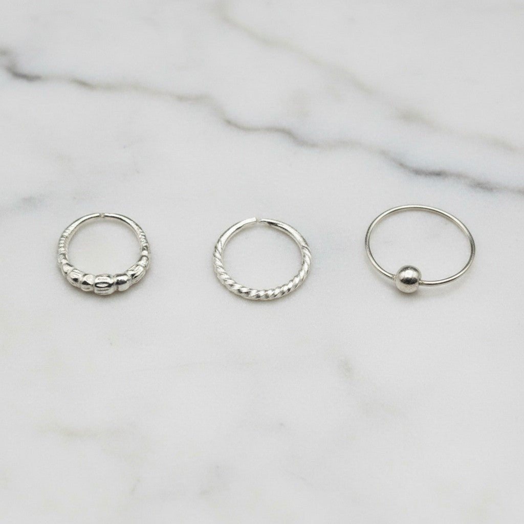 SilverStones.Pk pack of 3 silver nose rings with zircon, featuring beaded, twisted, and ball designs.