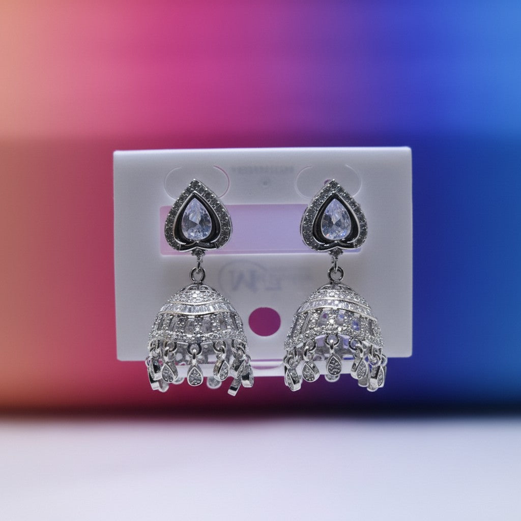 Silver color jhumka earrings with real zircon stones, heart-shaped top, and intricate bell design. Perfect for parties and weddings.
