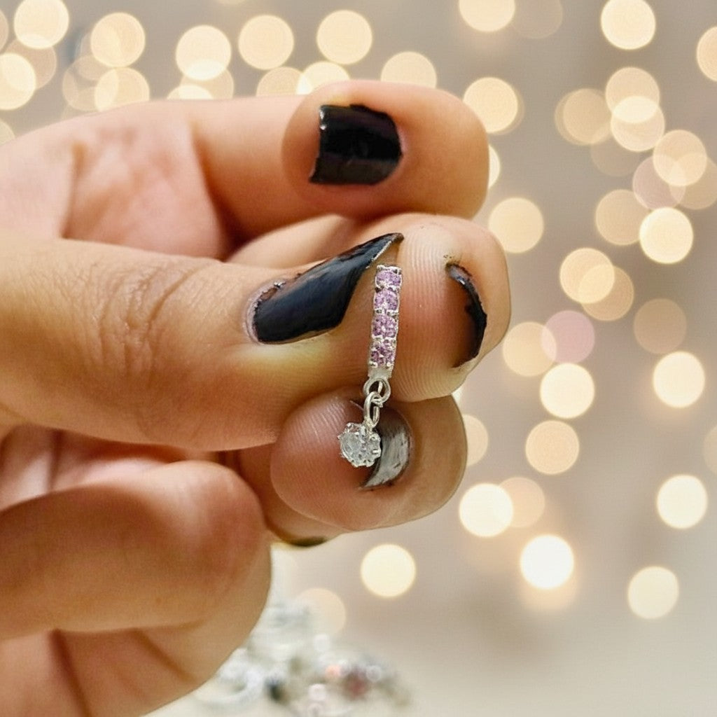 SilverStones.Pk 10mm silver nose ring with a dangling zircon and pink stones. Delicate design for everyday elegance.