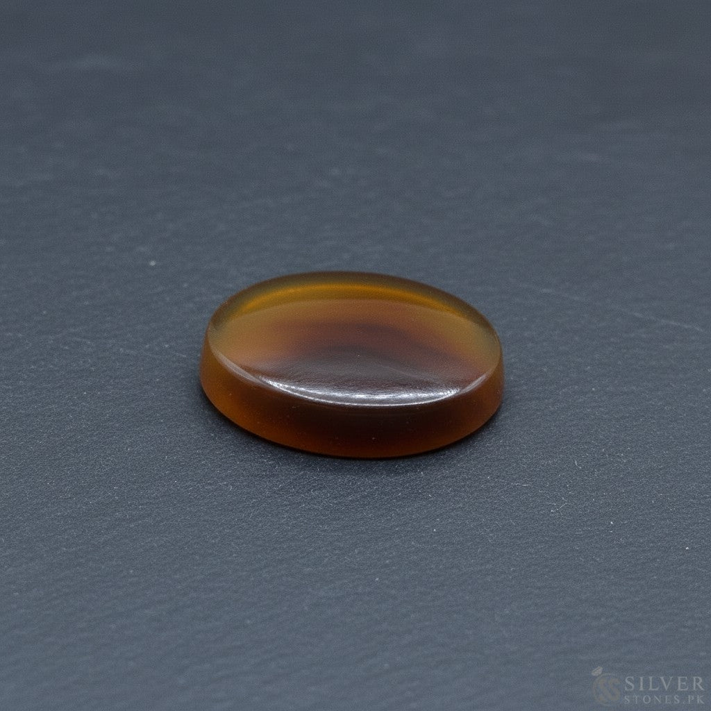 SilverStones.Pk oval Sulemani Aqeeq stone, deep brown and amber hues, polished finish, natural banding.