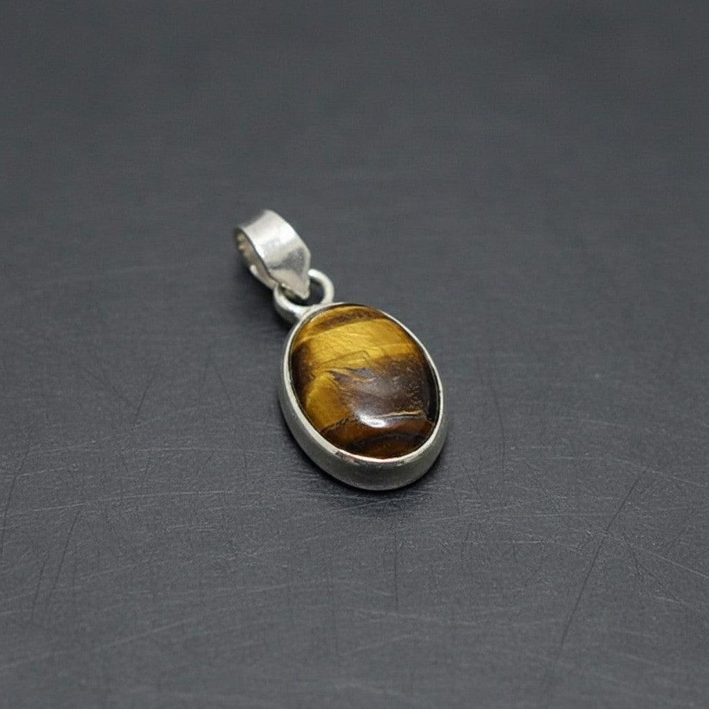SilverStones.Pk oval tiger eye stone pendant with silver bail. Features golden brown banding.