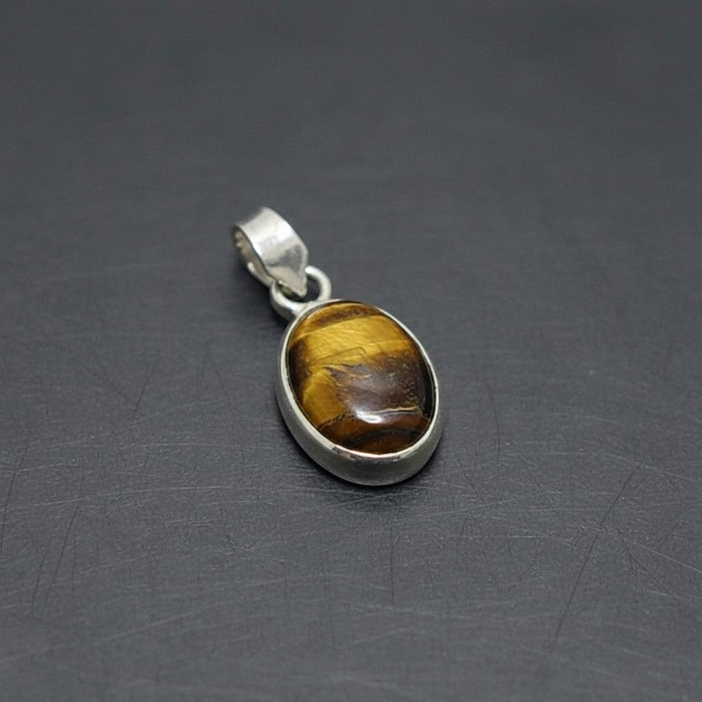 SilverStones.Pk oval tiger eye stone pendant with silver bail. Features golden brown banding.