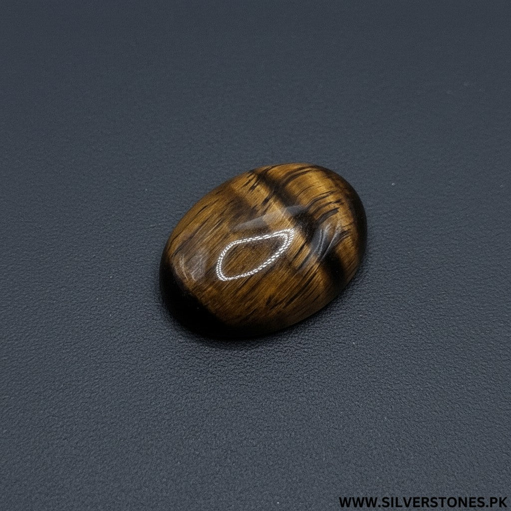 SilverStones.Pk oval polished tiger eye gemstone with golden brown stripes and chatoyancy.