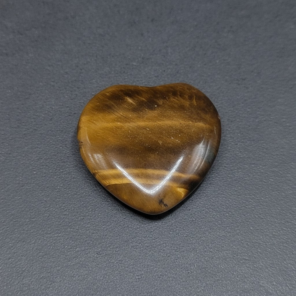 SilverStones.Pk heart-shaped tiger eye stone with golden and brown stripes, symbolizing strength and protection.