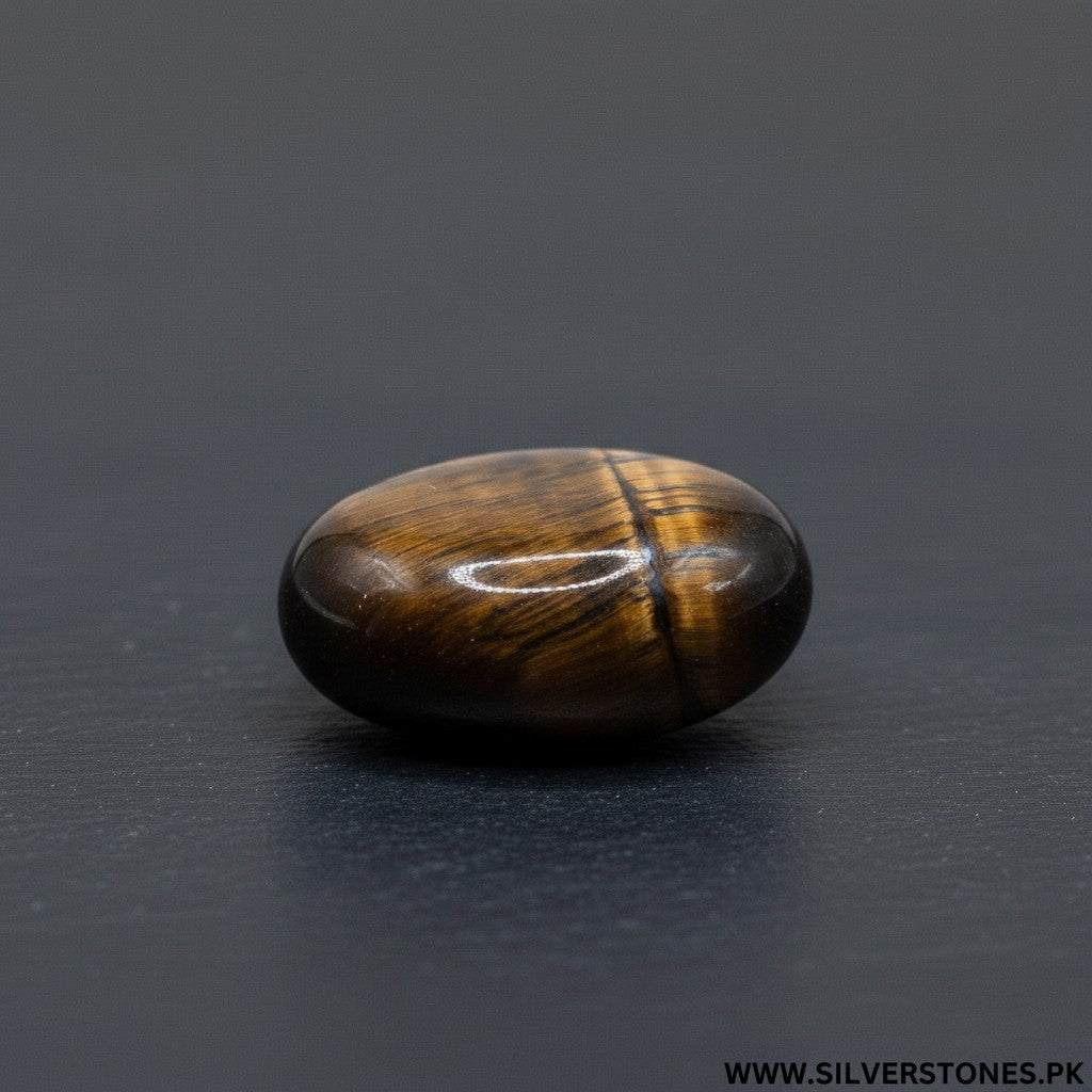 SilverStones.Pk oval polished tiger eye stone with brown and golden stripes, known for strength and protection.