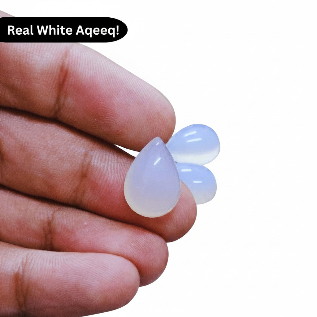 SilverStones.Pk real white aqeeq stones, teardrop cut, translucent with subtle banding, held in hand.