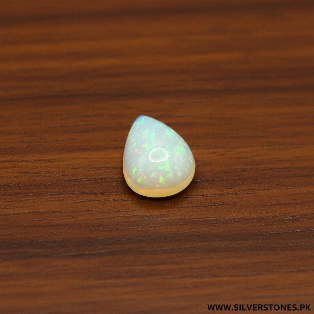 SilverStones.Pk pear-shaped white Ethiopian opal gemstone with iridescent flashes of green and orange.