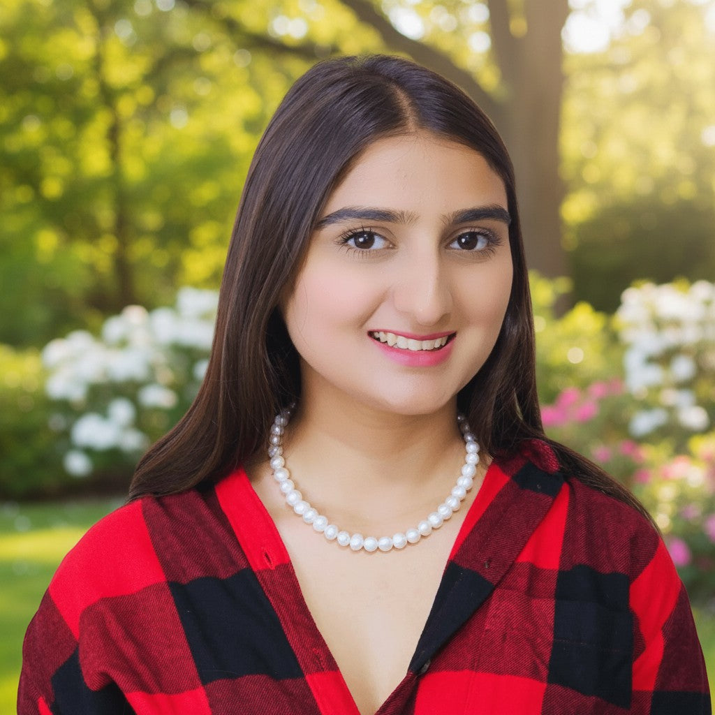 SilverStones.Pk white pearl necklace on a young woman wearing a red and black plaid shirt.