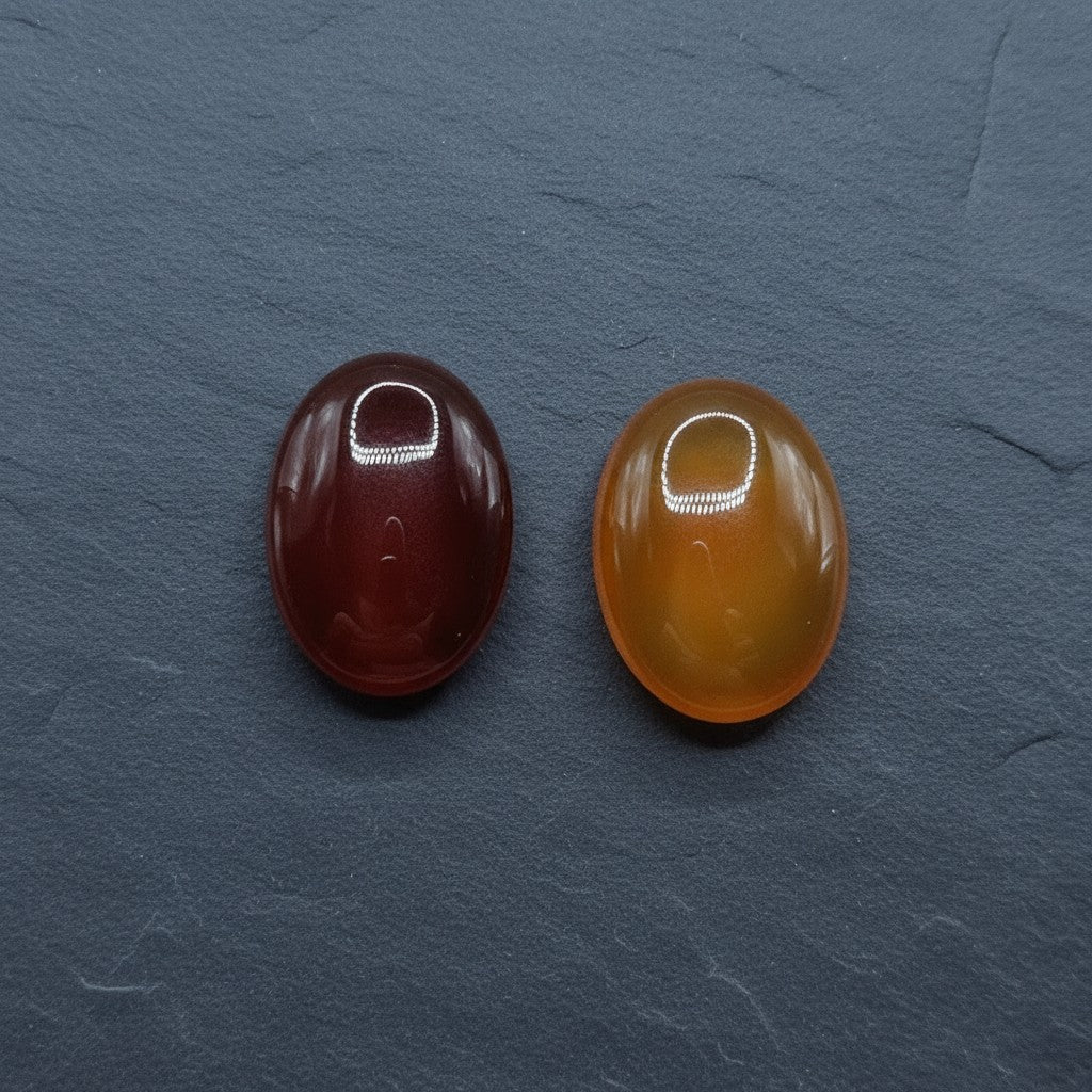 SilverStones.Pk two oval Yamni Aqeeq stones, one deep red, the other orange, showcasing natural banding and polished finish.