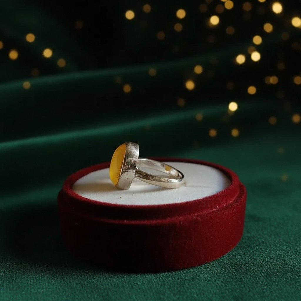SilverStones.Pk handmade silver ring featuring a smooth, oval, yellow Aqeeq gemstone. Presented in a red velvet ring box.